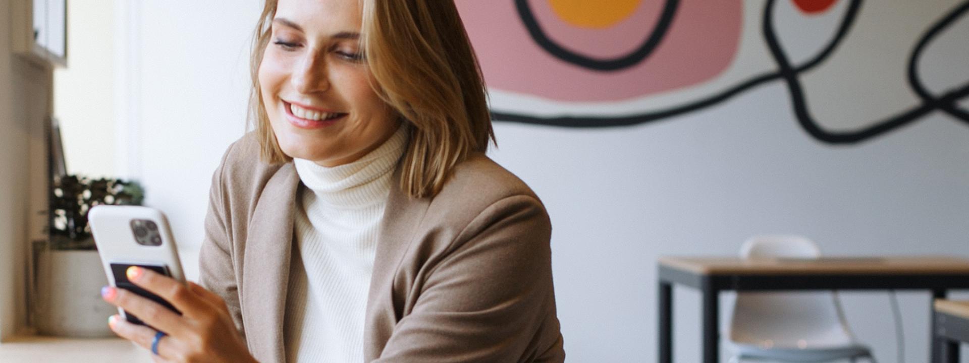 woman learning on phone in cool cafe